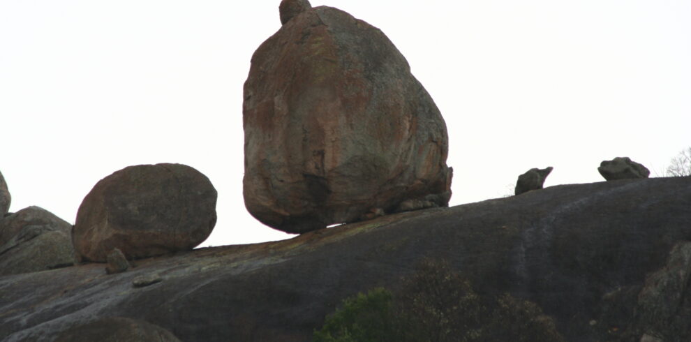 Grandi massi di granito sferici in precario equilibrio su una cresta rocciosa sotto un cielo chiaro nel Parco Nazionale di Matobo.
