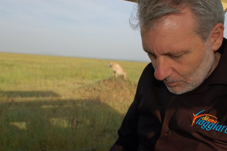 Walter Rubeo in safari nel Serengeti con un ghepardo sul termitaio alle spalle