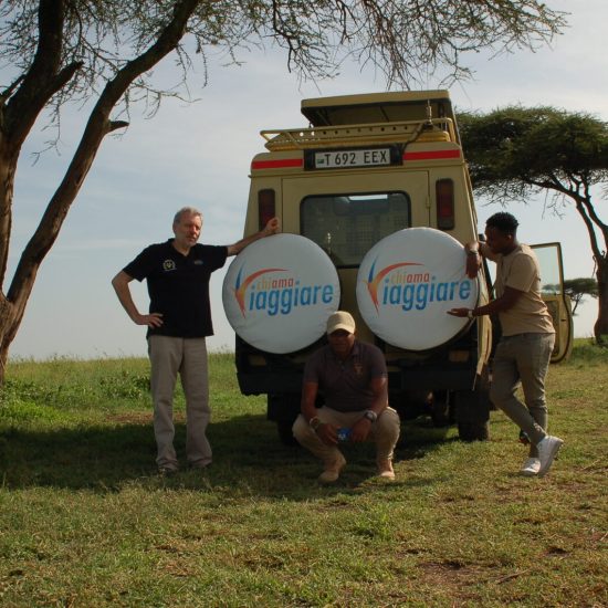 SDC Walter Rubeo con la guida tanzaniana nel Parco Nazionale del Serengeti Tanzania Walter Rubeo con la guida e l'equipaggio tanzaniani accanto al fuoristrada da safari di ChiAma Viaggiare nel Parco del Serengeti.